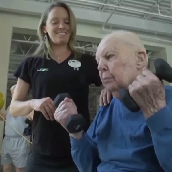 hombre de 103 años hace ejercicio en un gimnasio