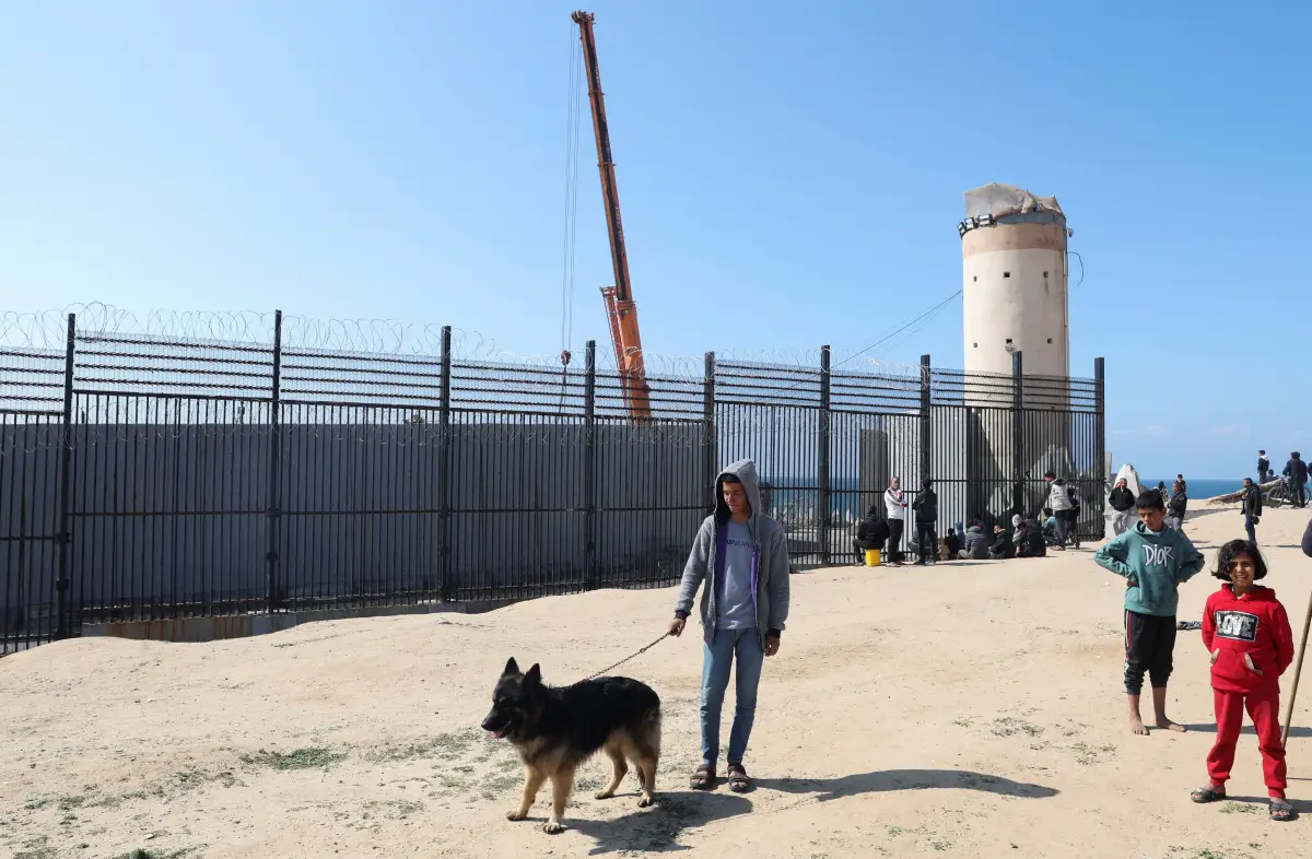 El adolescente palestino desplazado Hassan Abu Saman sostiene a su perro mientras lo pasea en la frontera con Egipto, en medio del conflicto en curso entre Israel y el grupo islamista palestino Hamas, en Rafah, en el sur de la Franja de Gaza, el 20 de febrero de 2024.