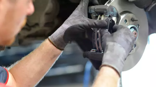 car mechanic repairs breakes from vehicle in a workshop