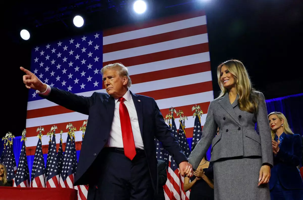 El candidato presidencial republicano y ex presidente de los Estados Unidos, Donald Trump, sostiene un puño mientras sube al escenario con su esposa Melania y su hijo Barron, siguiendo los primeros resultados de las elecciones presidenciales de Estados Unidos de 2024 en el Centro de Convenciones del Condado de Palm Beach, en West Palm Beach, Florida, EE. UU., 6 de noviembre de 2024