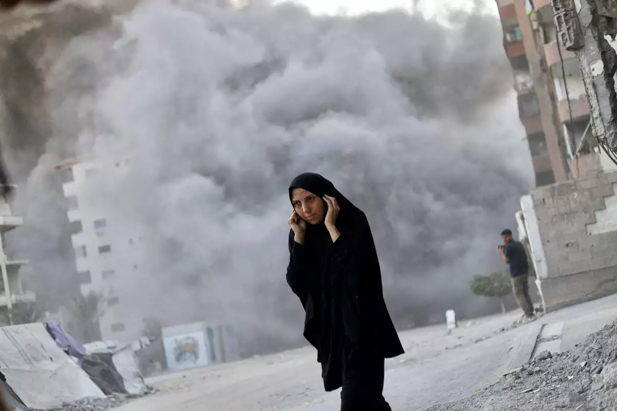 Una mujer palestina reacciona cuando el humo se eleva, mientras un edificio residencial se derrumba después de un ataque aéreo israelí, en la ciudad de Gaza, 7 de septiembre de 2025.