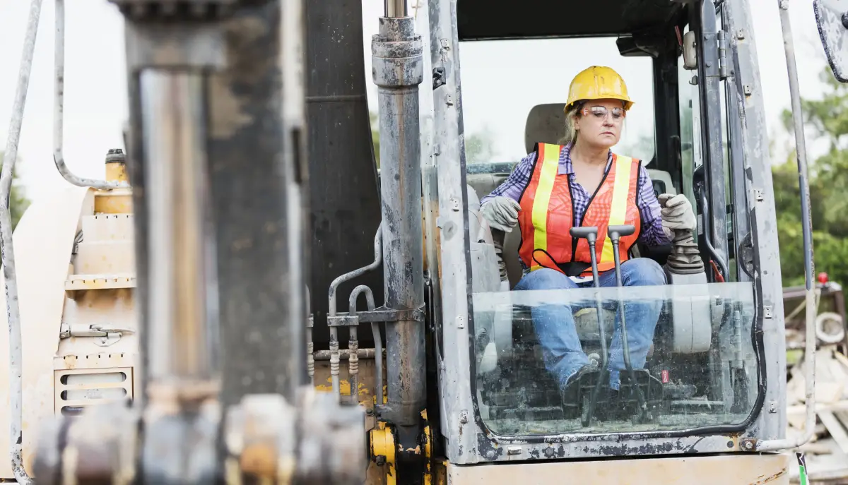 Hispanic female construction worker driving earth mover
