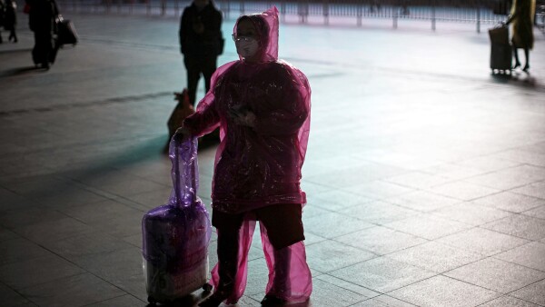 Woman wears face mask and plastic raincoat as a protection from coronavirus in Shanghai