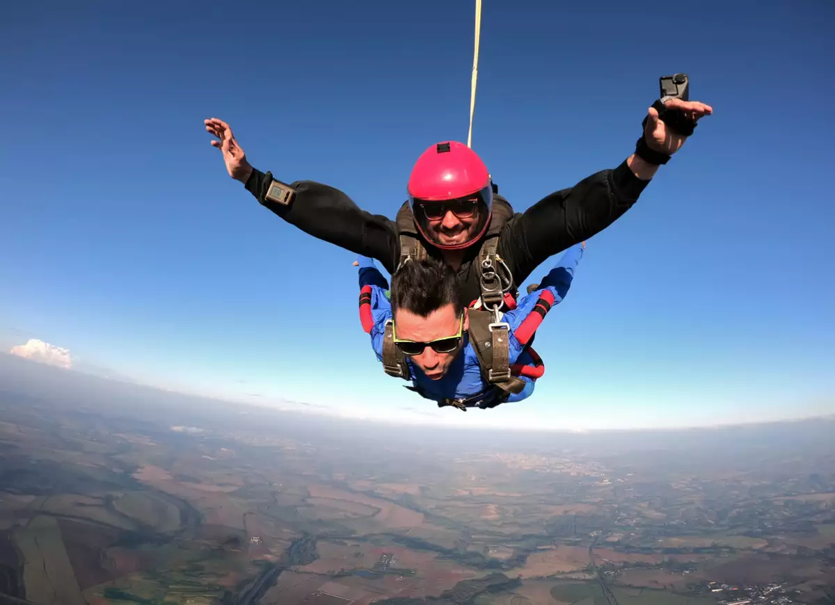 Foto de hombre en salto libre con paracaidas.