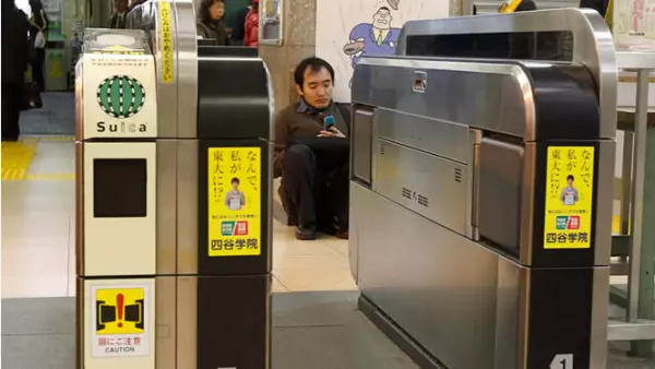 Un hombre se sienta en el suelo de una estación de trenes, luego de que los servicios de metro fueron suspendidos.