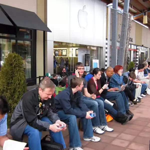 Muchos miran sus teléfonos celulares y computadoras mientras esperaban la salida de la iPad 2, en la tienda de Apple en Boulder, Colorado.