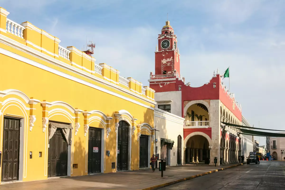 Morning view of Municipal Palace (Palacio Municipal) with clock tower and street with people in Merida, Yucatan, Mexico