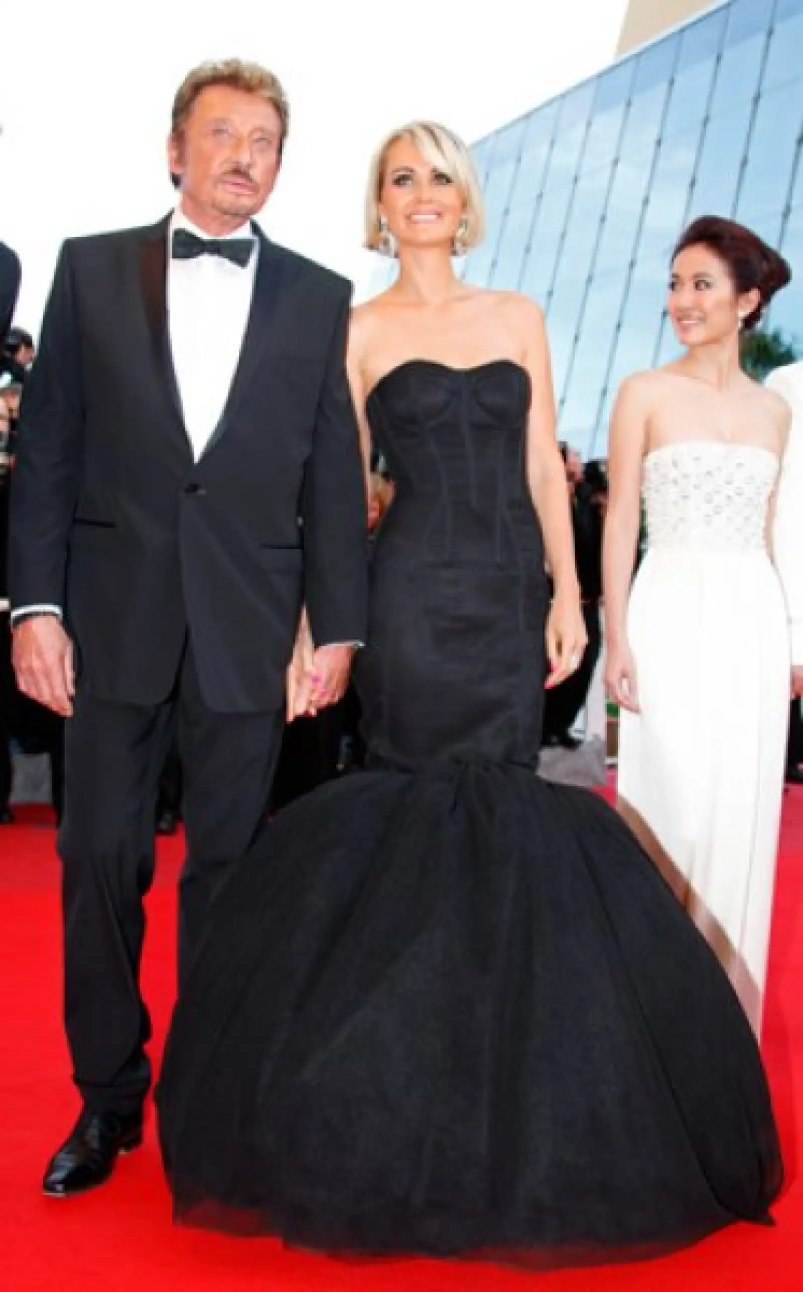 El actor y cantante francés Johnny Hallyday y su esposa Laeticia llegan con la actriz Michelle Ye of Hong-Kong a la presentación de "Vengeance", dirigida por Johnnie To.
