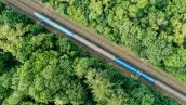 Aerial view of a train driving through a forest. Double track, near Prague, Czech Republic.