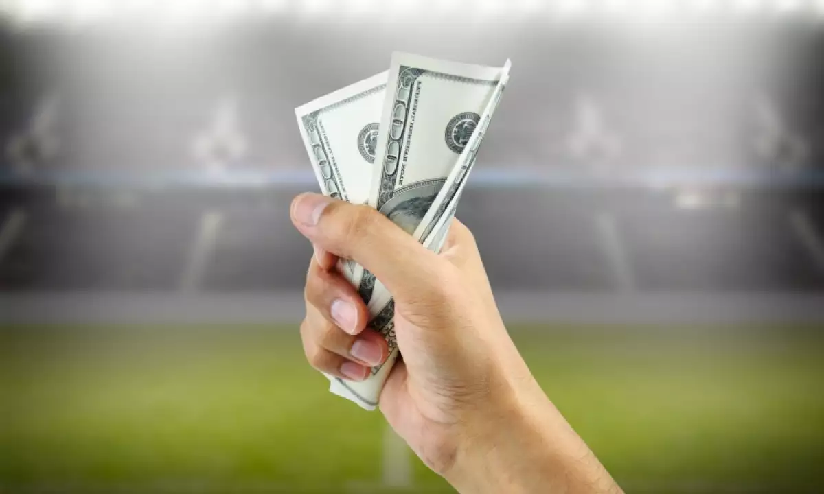 Una mano sujeta un par de billetes: el sueldo promedio del futbol femenil en México es alarmantemente bajo