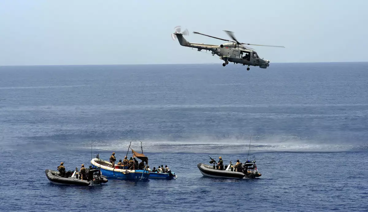 Supuestos piratas se rinden y entregan mientras un helic�ptero y botes navales se acercan para aprehenderlos