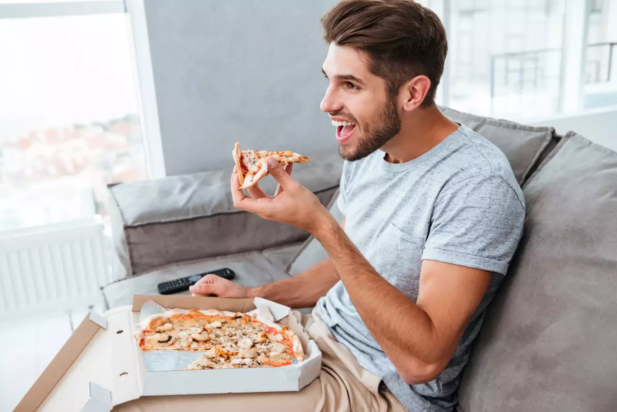 Hombre comiendo pizza