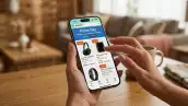 Manos sosteniendo un iPhone con la página de ofertas de Amazon abierta, donde aparece la leyenda “Prime Day” y productos con descuentos de 25%, 15% y 10%.