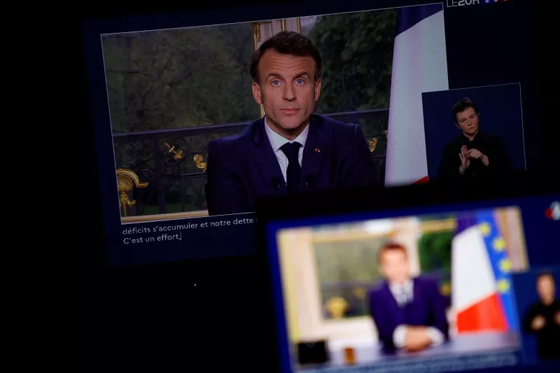 El presidente francés Emmanuel Macron aparece en una pantalla, mientras habla durante un discurso especial a la nación desde el Palacio del Elíseo, después de que promulgara la reforma de las pensiones que eleva la edad de jubilación, en París, Francia, el 17 de abril de 2023.