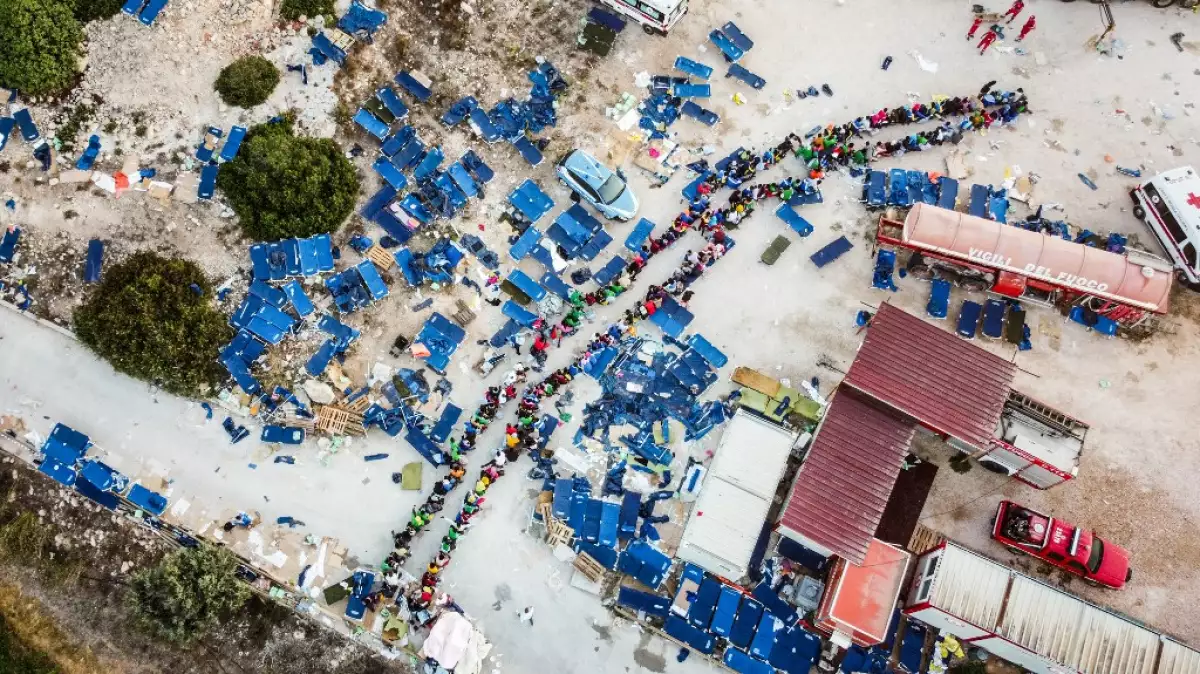 Esta fotografía aérea tomada el 14 de septiembre de 2023 muestra a los migrantes reuniéndose fuera del centro operativo llamado "Hotspot" en la isla italiana de Lampedusa.