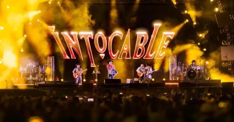 Cuatro músicos con en un escenario con luces de color rojo.jpg