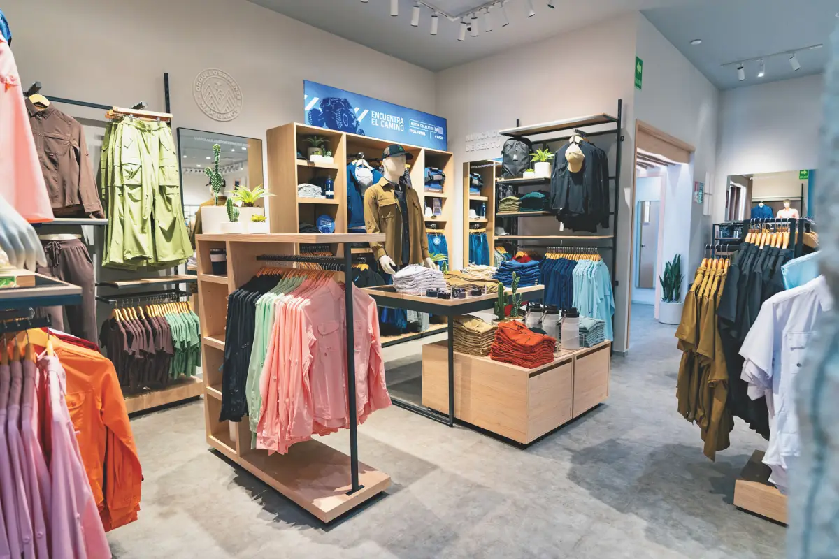 Una tienda de MAJA Sportsware en donde se muestran diferentes tipos de ropa especializada para actividades al aire libre, como pesca deportiva o senderismo.