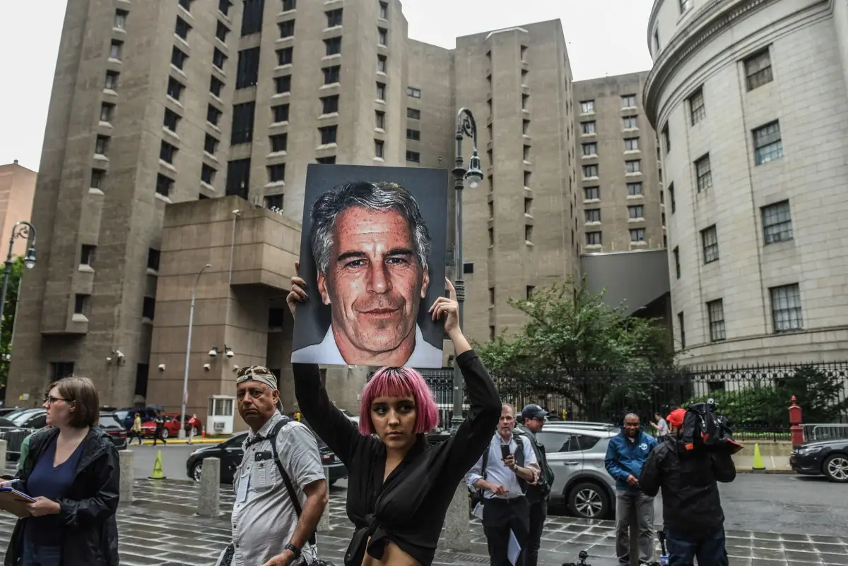 Un miembro de un grupo de protesta llamado "Hot Mess" sostiene un cartel de Jeffrey Epstein frente al Centro Correccional Metropolitano el 8 de julio de 2019 en la ciudad de Nueva York