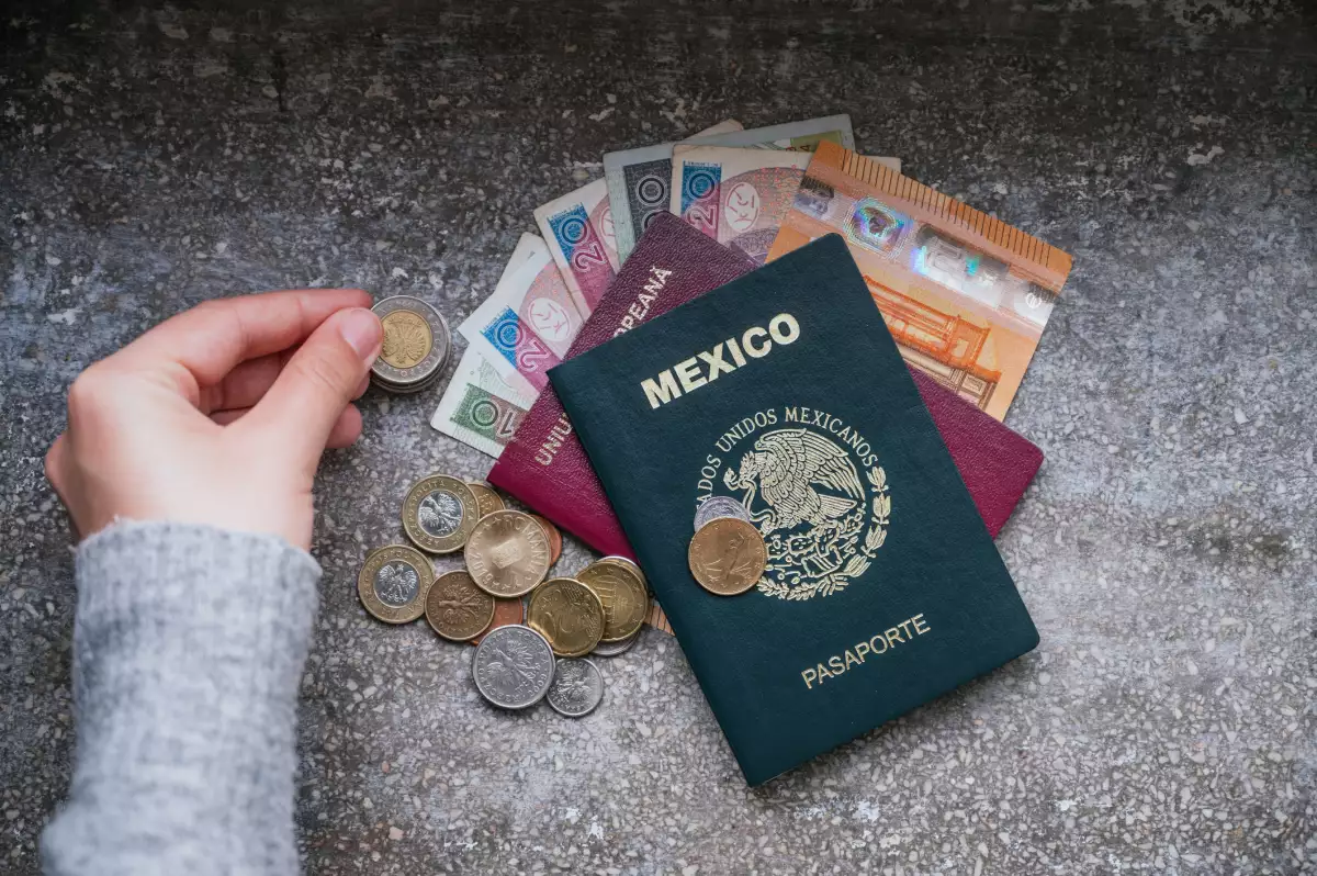 Contando dinero de diferentes países y un pasaporte mexicano y un pasaporte rumano en un lado.