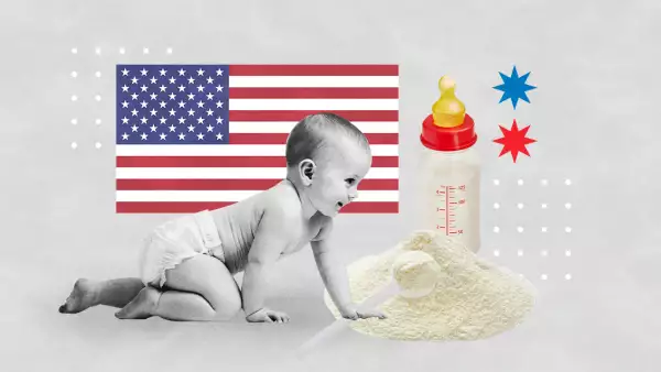 Bebé gatea junto a un biberón y un montón de fórmula láctea con la bandera de EU de fondo. 