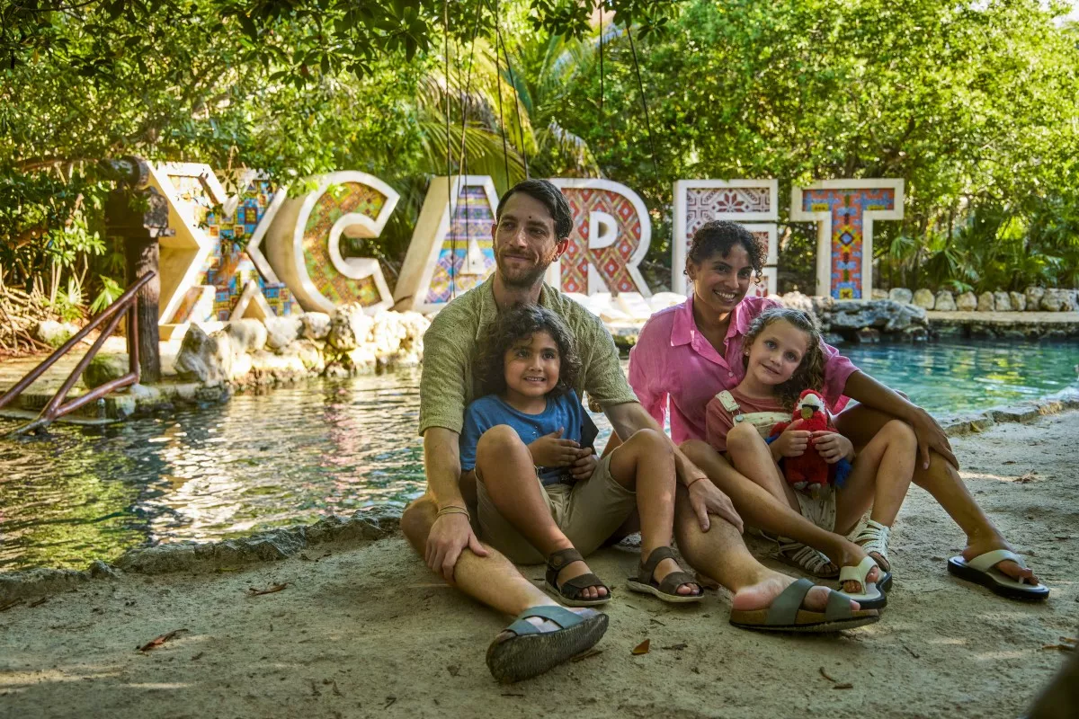 Papá, mamá y sus dos hijos posan para tomarse una foto en Xcaret. 