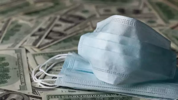 edical face mask and dollar banknotes, world coronavirus epidemic and economic losses concept.