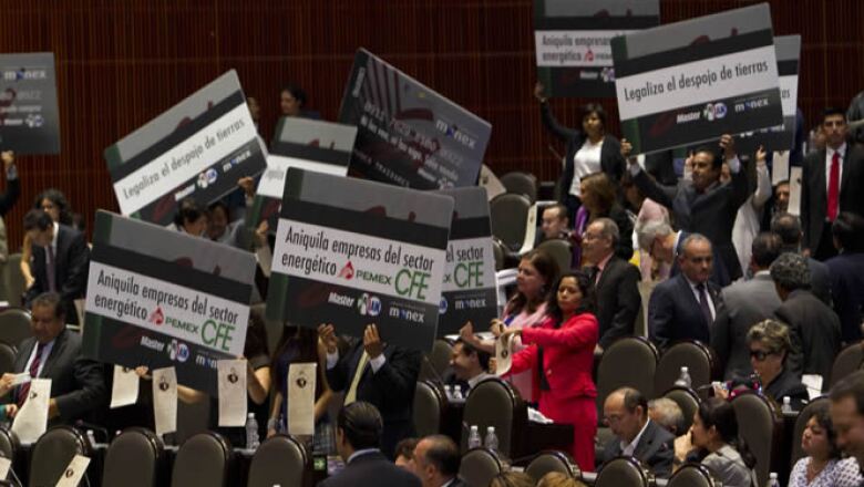 Desde sus curules los diputados mostraban carteles en forma de monederos electrónicos en los que escribieron consignas que acusan que la nueva legislación es un despojo.