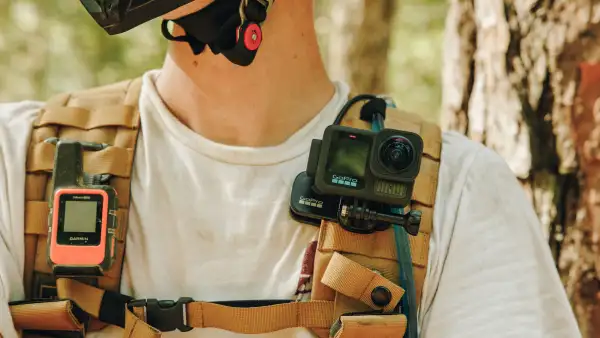 Primer plano de una cámara GoPro sobre el hombro de un usuarios, quien parece ser un ciclista de montaña.