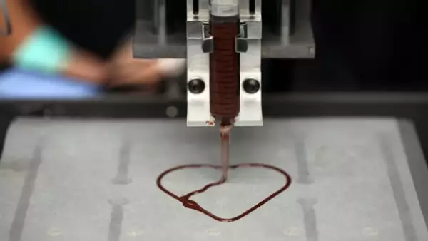una impresora 3-d crea un chocolate en forma de corazon