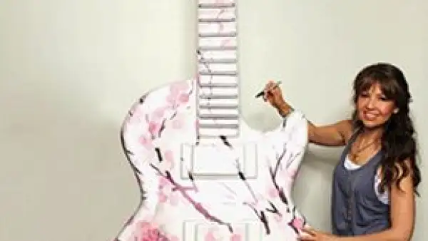 La cantante y actriz mexicana Thalía se une a la exposición de Miami GuitarTown al firmar una de las
esculturas en forma de guitarra Gibson Les Paul, de 10 pies de altura.