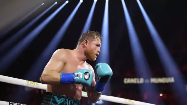 Foto de Saúl Canelo Álvarez sobre el ring con guantes azules y luces sobre él.