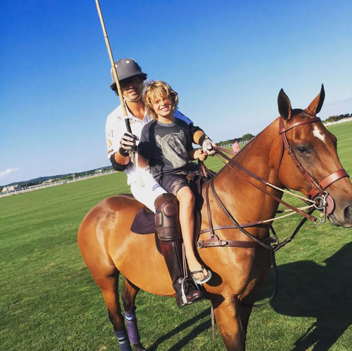 Moses posando sobre un caballo con el jugador Argentino, Nacho figueras.