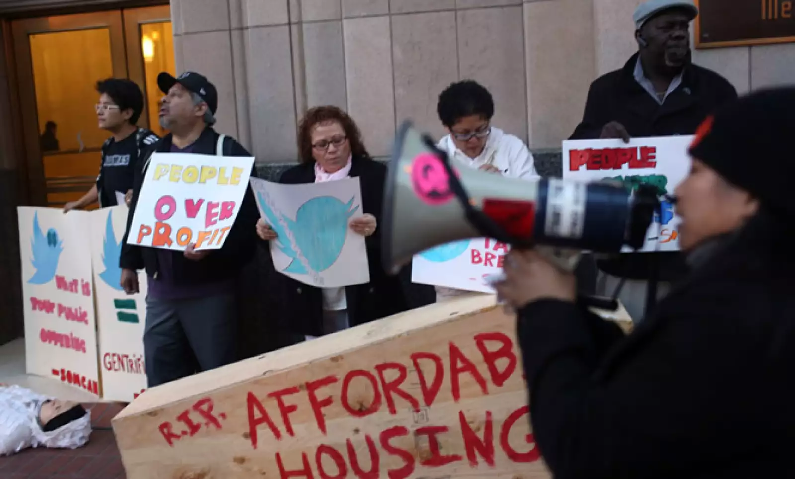 Un grupo de personas se manifestó contra los recortes de impuestos corporativos y los altos costos de la vivienda durante el debut del microblog.