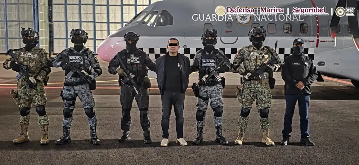 Iván "N", "El Tanque", esposado junto a elementos de seguridad tras su captura. 
