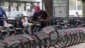 Un usuario del sistema de movilidad personal Ecobici ajusta una bicicleta, en una de sus estaciones, ubicadas en avenida Reforma.