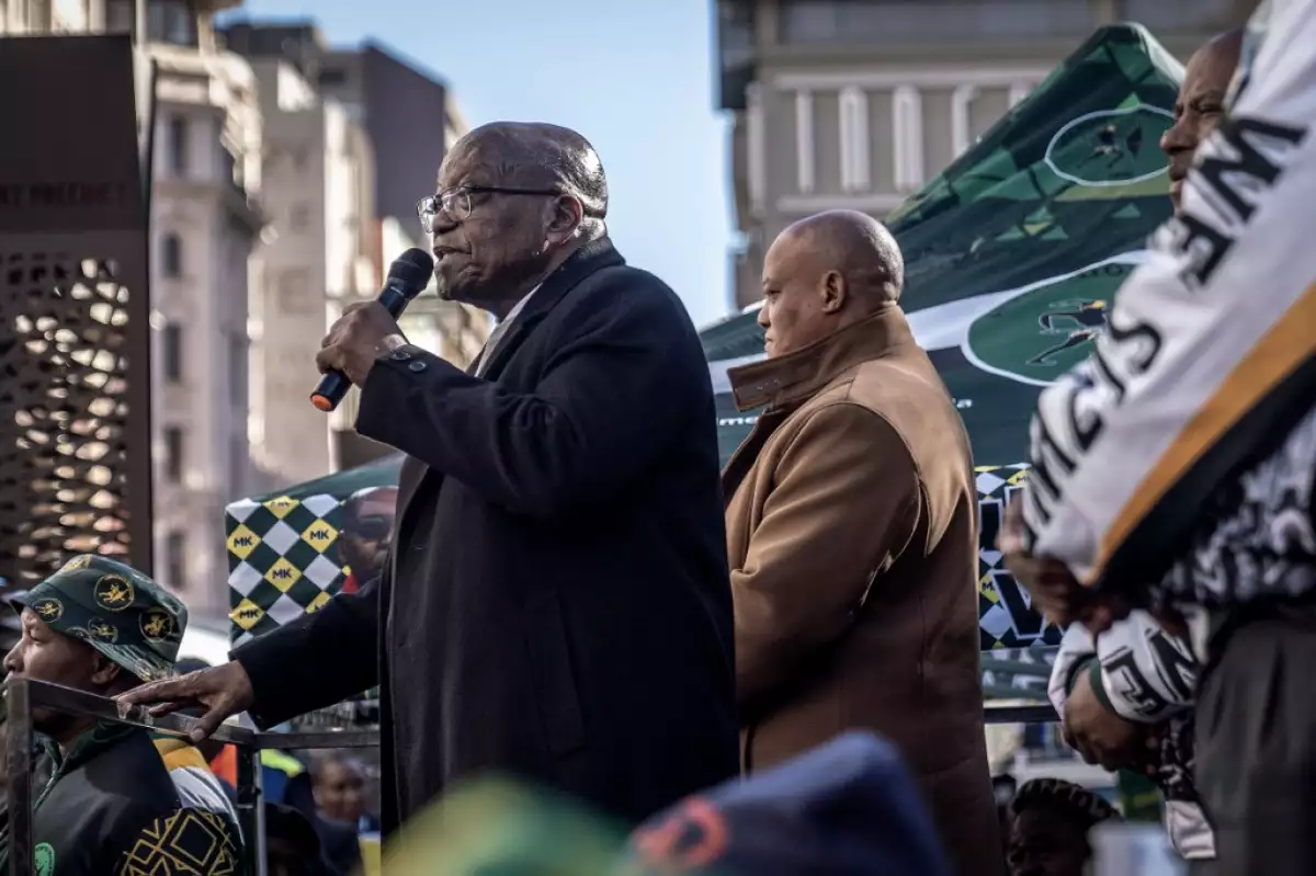 El líder del partido uMkhonto weSizwe (MK) y ex presidente de Sudáfrica, Jacob Zuma (izq.), se dirige a sus partidarios frente al Tribunal Superior de Johannesburgo el 3 de junio de 2024, después de que el líder expulsado Jabulani Khumalo se dirigiera al Tribunal Electoral para ser reinstalado.