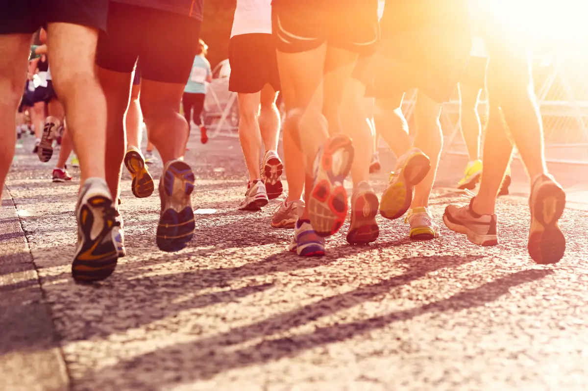 Carreras de maratón que compiten por el buen estado físico y los pies saludables de estilo de vida activo en la carretera