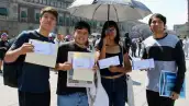 Tres hombres yuna mujer joven que muestran un sobre. Están en la plancha del Zócalo de la CDMX bajo el sol.jpg
