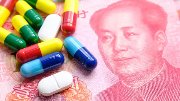 Pila de diferentes píldoras de colores colocadas junto a billetes de 100 yuanes.