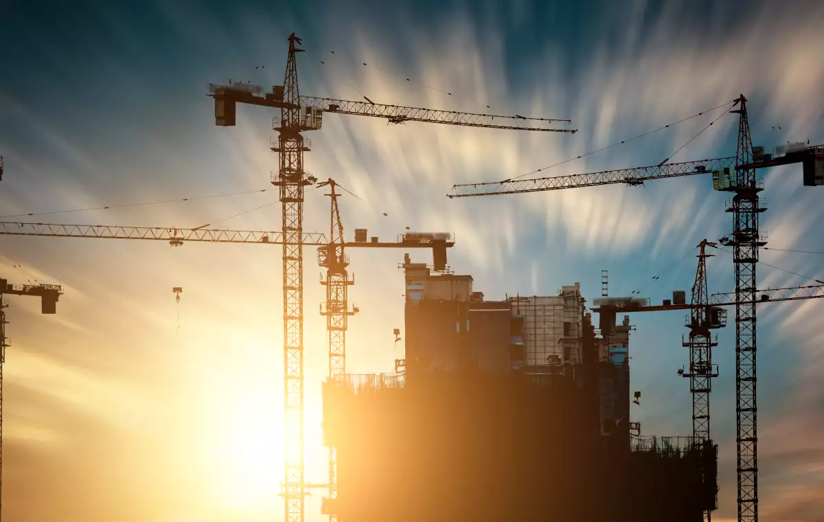 Construction cranes at sunset