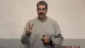 Con un fondo de color gris y blanco, Nicolás Maduro aparece con una sudadera gris, haciendo la señal de paz con una mano, sosteniendo sus lentes y un reloj en su muñeca izquierda.