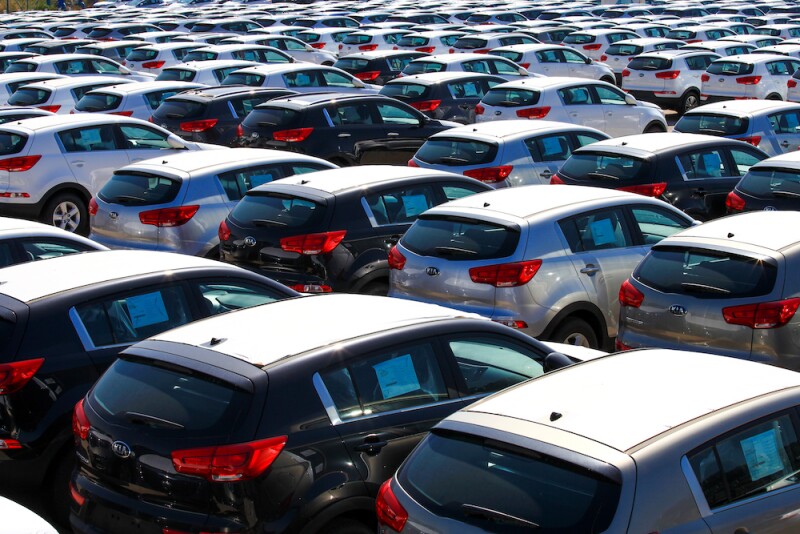 Rows of new cars covered in protective white sheet
