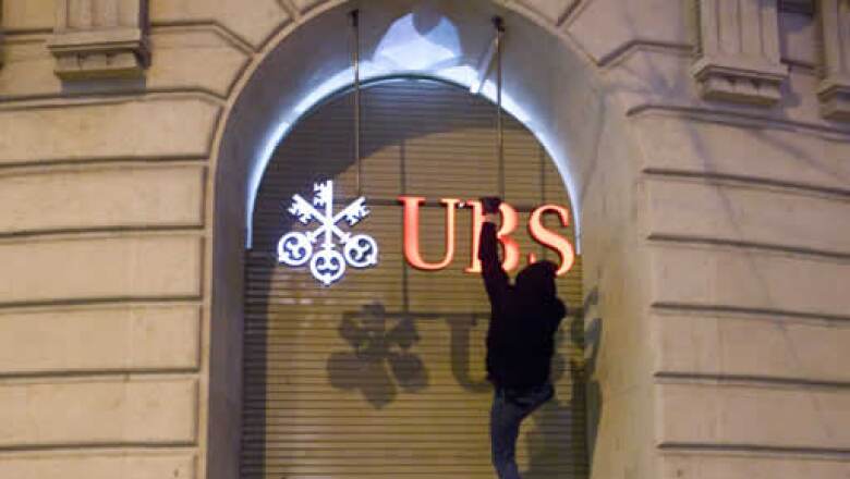 Un activista se colgó del logo de una sucursal del banco suizo UBS en Basilea para protestar contra la cumbre económica que se realiza en Davos. (Foto: Reuters)