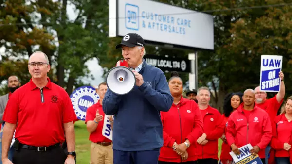 El presidente de los Estados Unidos, Joe Biden, habla junto a Shawn Fain, presidente de United Auto Workers (UAW), mientras se une a los miembros en huelga de United Auto Workers (UAW) en la línea de piquete fuera del Centro de Distribución Willow Run de GM, en Belleville, Condado de Wayne, Michigan, Estados Unidos, el 26 de septiembre de 2023.