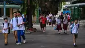 Los padres acompañan a sus hijos mientras las clases se abren para el nuevo año escolar en una escuela primaria en Manila el 8 de junio de 2026.