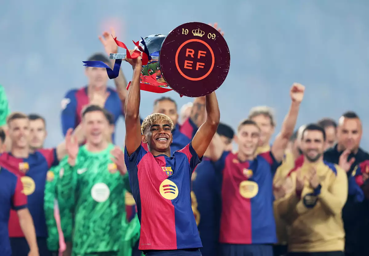 Foto de Lamine Yamal cargando el trofeo de LaLiga luego de que el Barcelona venció al Villarreal el 18 de mayo de 2025.