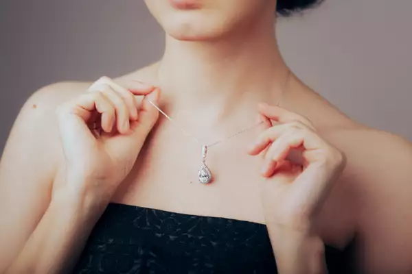 Mujer elegante mostrando su hermosa y preciosa pieza de joyería de moda