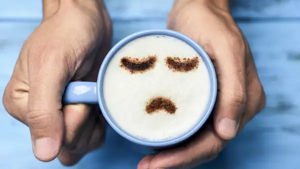 Unas manos sostienen una taza con una cara triste, en referencia al blue monday, el día más triste del año. 