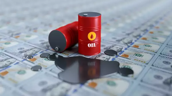 Red Oil Drums Sitting on One Hundred American Dollar Banknotes- Oil Industry Concept