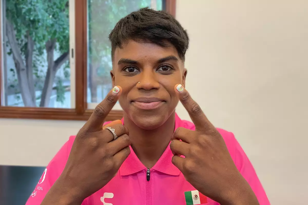 Foto de la judoca mexicana Prisca Awiti Álvarez mostrando su manicure con la bandera olímpica pintada.